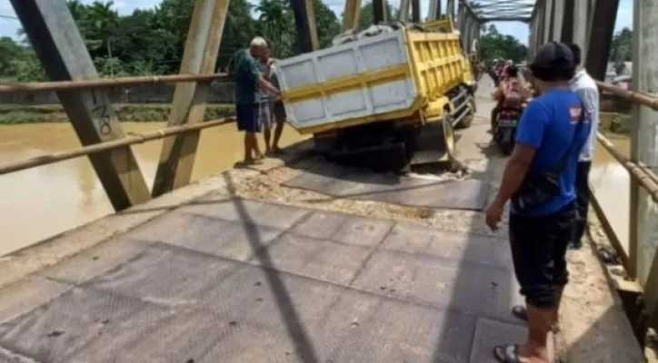 Warga saat mengevakuasi truk yang nyangkut di jembatan Surianen Pandeglang. (Foto: Ist).