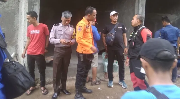 Anggota Bhabinkamtibmas Aipda Sadikin bersama tim SAR gabungan berupaya pencarian tubuh korban menggunakan perahu menyisir Kali Ciliwung. (ist)