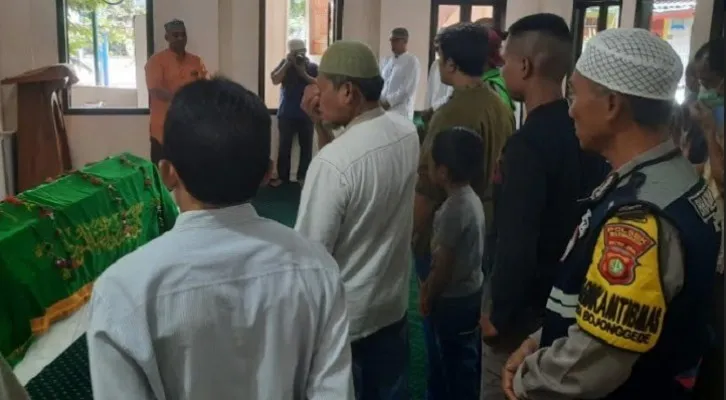 Anggota Bhabinkamtibmas Desa Bojonggede Aipda Sadikin mengikuti Salat untuk Jenazah bocah 8 tahun di Kali Ciliwung. (Angga)