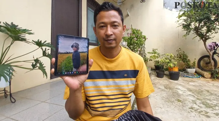 Iing Syaputra saat menunjukkan foto anak laki-lakinya berusia 2 tahun 11 bulan yang meninggal setelah mengidap penyakit gagal ginjal akut. (Foto: Pandi)