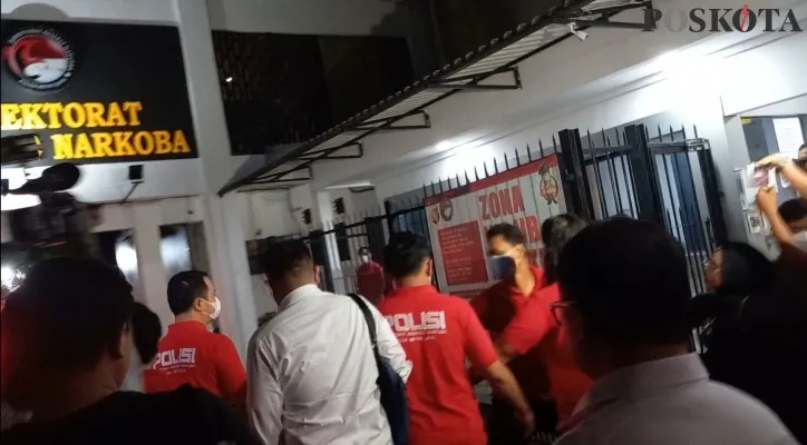 Anggota Ditresnarkoba Polda Metro Jaya menutup pintu gerbang guna menghalau awak media mengikuti mobil yang membawa Irjen Tessy Minahasa.(Foto: Andi Adam Faturahman)