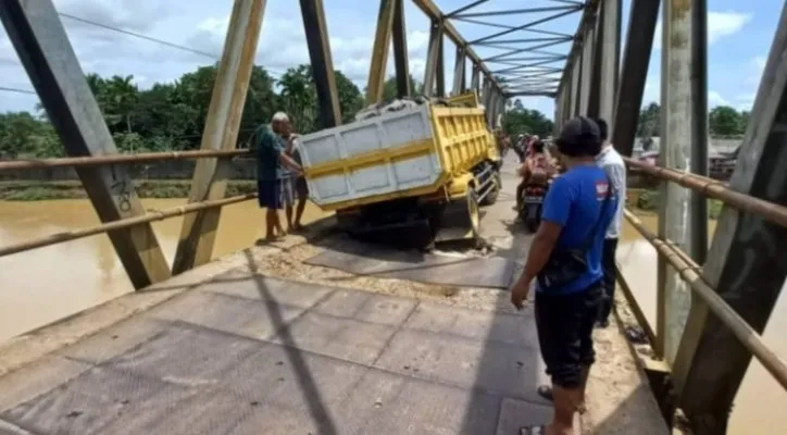 Ban truk pengangkut batu terperosok di Jembatan Surianen Pandeglang. (foto: ist)