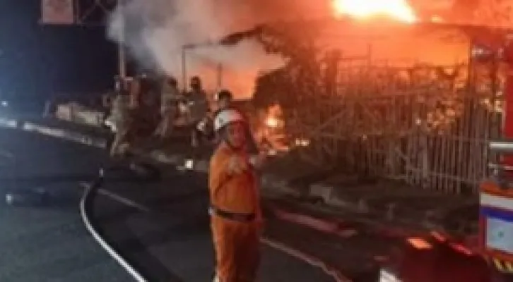 Petugas Damkar Kota Depok mencoba proses pendinginan bangunan tambal ban dan usaha tanaman hias di Jalan Raya Bogor terbakar hebat. (Ist)