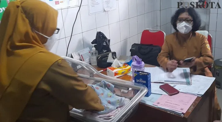 Bayi laki-laki yang ditemukan warga di kolong meja warung saat dilakukan perawatan di Puskesmas Gunung Putri. (foto: poskota/panca)