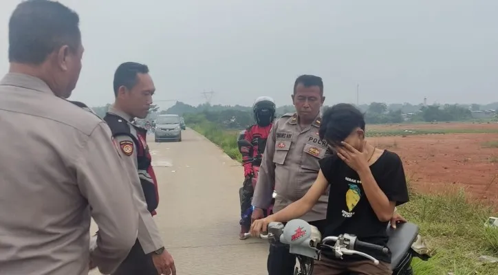 Seorang remaja yang tengah balap liar di Jalan Raya Bomang mewek meminta tolong ke polisi tidak diangkut ke mobil. (Ist)