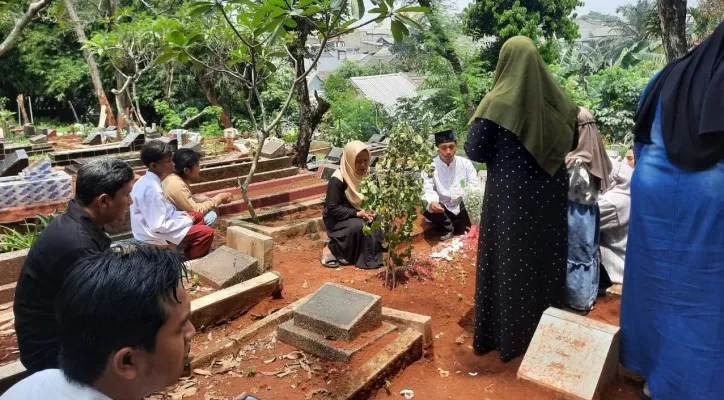 Guru dan siswa melakukan takziah ke makam korban. (Foto: Angga)