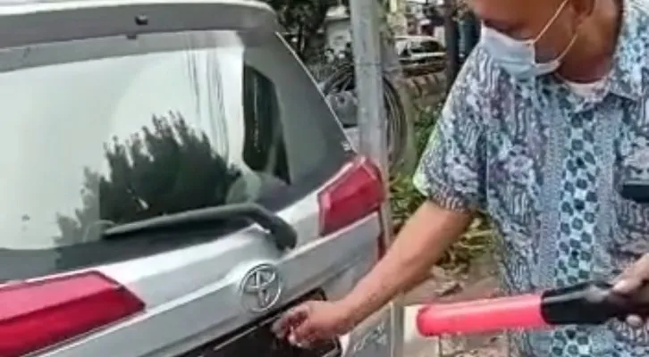 Polisi memberikan teguran kepada pengemudi mobil yang menutupi plat nomor kendaraan menggunakan lakban hitam, agar tak perpindai kamera ETLE.(Foto: Tangkapan layar unggahan video akun @tmcpoldametro)