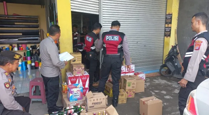 Personil Satuan Samapta saat menginventarisir jumlah miras yang diamankan dari warung jamu. (ist)