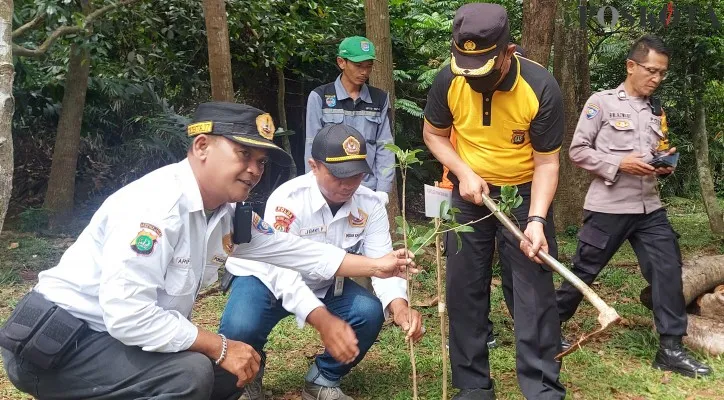 Kapolsek Pancoran Mas dan anggota Dewan Propinsi Rizki bersama para unsur muspika dan Karesort Pokdar Kamtibmas Bhayangkara menanam pohon di Taman Hutan Raya Cagar Alam Depok. (Foto: Angga)