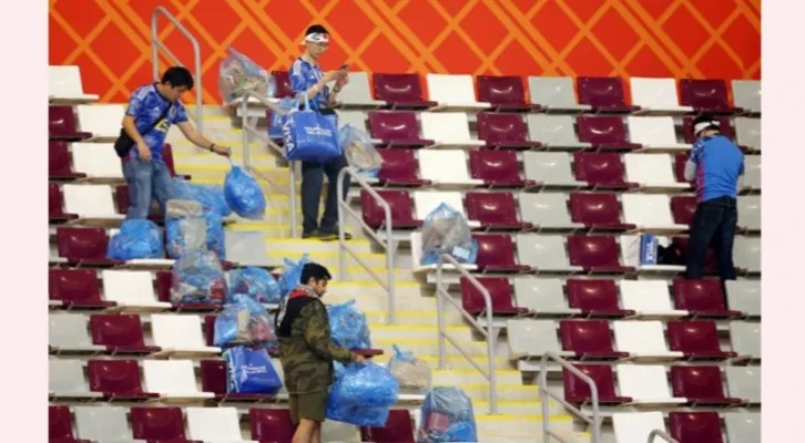 Meski Timnasnya menang atas Jerman, suporter Jepang tidak larut dalam euforia kemenangan, tapi malah bersih-bersih Stadion AL Khalifa. (Foto: twitter @JacobsBen/di Aljazeera)