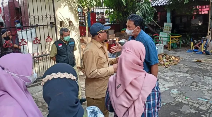 Anggota DPRD Kota Depok dari Partai Solidaritas Indonesia (PSI), Oparis Simanjuntak   sedang menengahi keributan ibu-ibu  yang tengah berada di sekolah. (Foto: Angga)