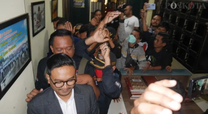 Sejumlah orang berseragam hitam kawal Y saat keluar dari ruang penyidik Polres Pandeglang. (Foto: Samsul Fatoni)