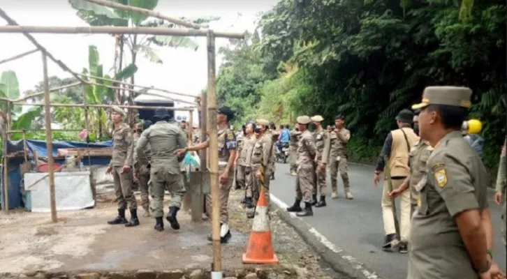 Ssatpol PP Kabupaten Bogor mengawasi PKL di Kawasan Puncak yang membongkar lapak masing-masing. (Foto: ist)