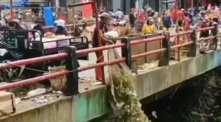 Tangkapan layar warga yang membuang sampah ke aliran sungai dari atas jembatan.(ist) 