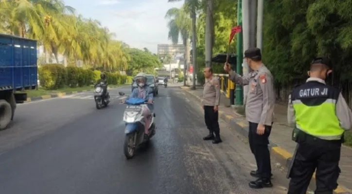 Petugas kepolisian saat mengawasi jalan terkait adanya tumpahan solar di jalan Jababeka Cikarang Bekasi. (Humas Polsek Cikarang ).