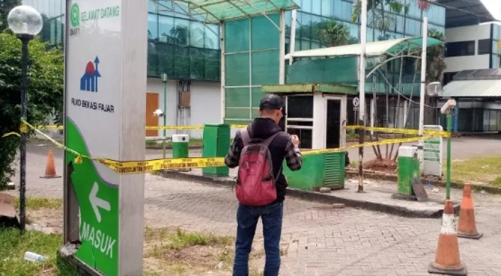 Salah satu warga saat melihat kondisi korban ditemukan tewas didepan pintu masuk ruko Bekasi Fajar, Cibitung Bekasi. (Foto: Ihsan Fahmi)