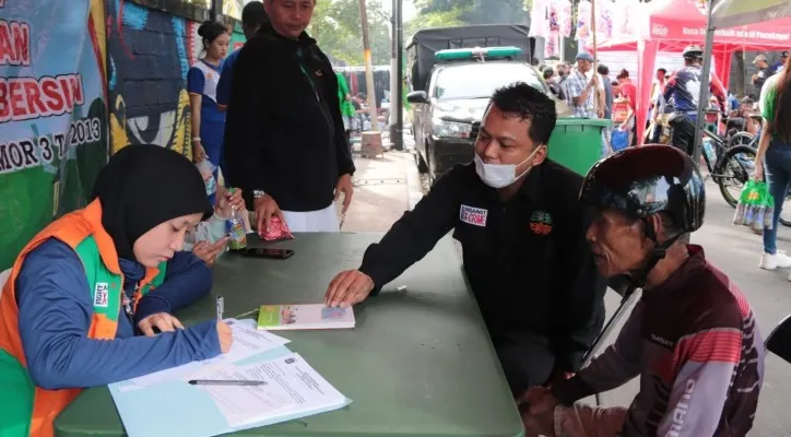 Petugas Dinas Lingkungan Hidup DKI memberikan denda kepada warga yang membuang sampah sembarangan.(Foto: DLH)