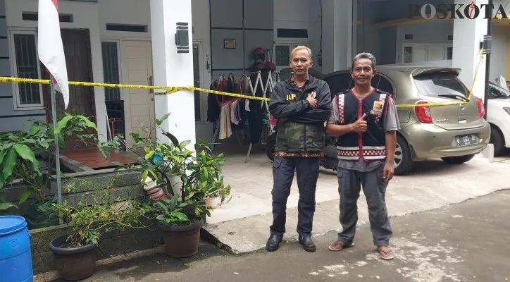 Tresno, security perumahan bersama anggota Pokdarkamtibmas mengamankan rumah korban pembunuhan yang dipasang garis polisi. (Foto: Angga)