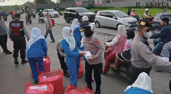 Kapolsek Cinere dengan jajarannya dan IKWI DKI Jakarta bagikan makanan takjil di Jalan Raya Cinere. (angga)