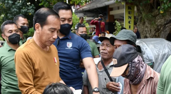 Foto: Presiden Jokowi bersama cucunya Jan Ethes bagikan bantuan ke warga di Surakarta, Jawa Tengah. (Birosetpres)