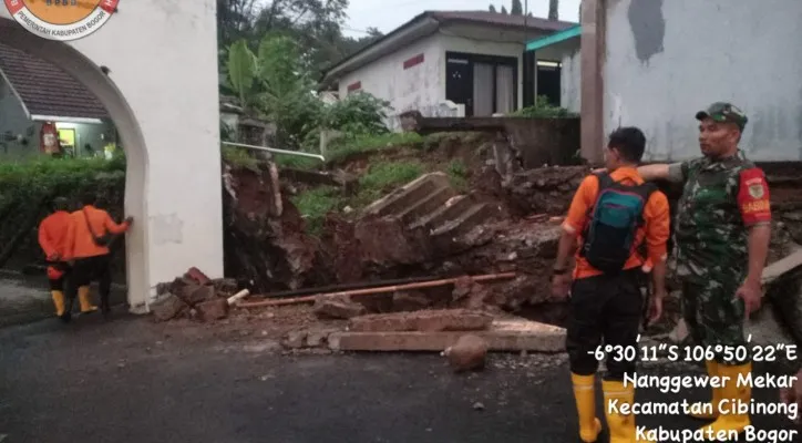 Petugas BPBD Kabupaten Bogor meninjau tanggul penahan tanah yang jebol di Cibinong saat hujan deras. (Ist)