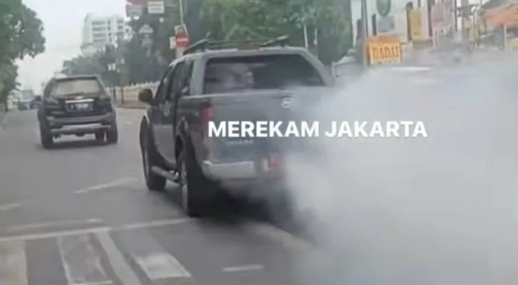 Viral mobil dinas Pemprov DKI mengeluarkan asep ngebul saat melintas di jalan raya, hingga ganggu pengendara. (tangkap layar)