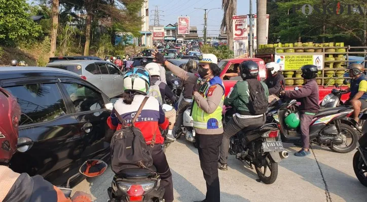 Polantas Polres Metro Depok melakukan pengaturan lalu lintas di lokasi kabel menjuntai di Jalan Raya Kartini hingga membuat kemacetan. (Angga)