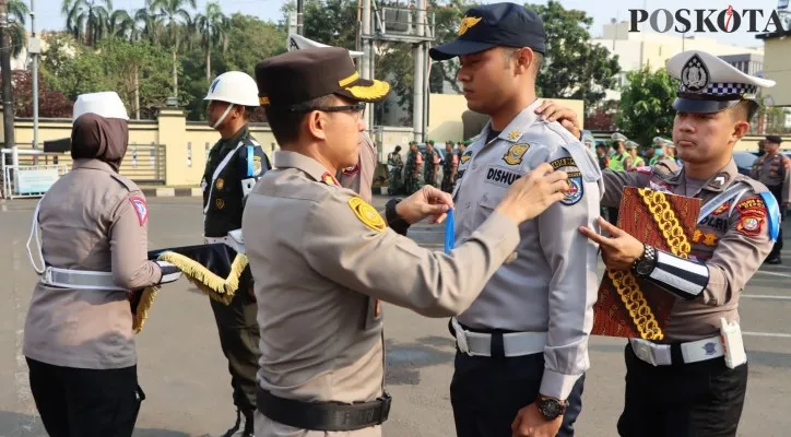 Wakapolres Metro Depok AKBP EKO WAHYU FREDIAN, S.I.K., M.M., menyematkan pita biru ke masing-masing perwakilan anggota pelaksanaan Operasi Zebra Jaya 2023 dibuka. (Angga)