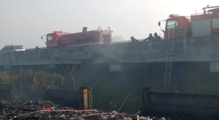 Teks Foto: Petugas damkar Kabupaten Bekasi saat memadamkan api di TPS Sumber Jaya, Bekasi. (ist)