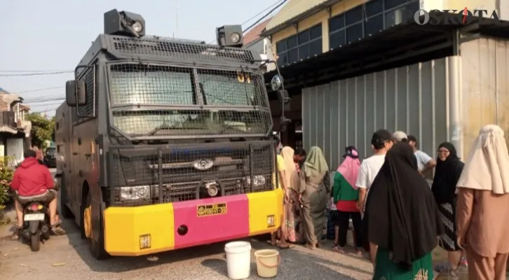 Teks Foto : Water Cannon dihadapan Warga Bekasi Utara saat antri air. (Ihsan Fahmi)