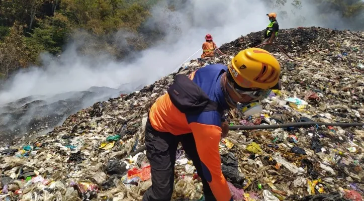 Teks Foto: Petugas upaya memadamkan api di TPA Tlekung. (ist)