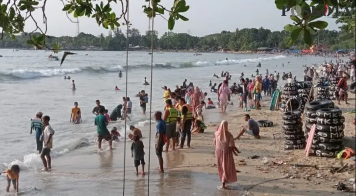 Caption: Suasana wisatawan saat liburan di salah satu objek wisata pantai di Carita Pandeglang. (Samsul Fatoni)