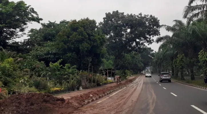 Situasi Jalan Raya Pemda tertutup tanah merah akibat dari bekas lalu lalang truk pengangkut tanah galian ilegal di kawasan tersebut yang kini sudah ditutup. (Veronica)