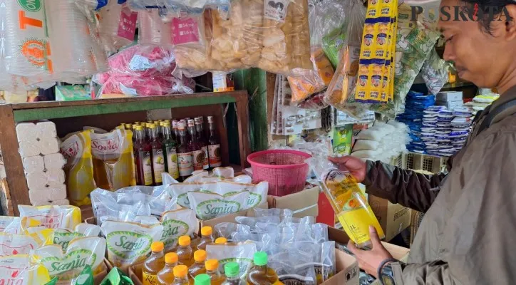 Salah satu pengunjung saat melihat stok minyak goreng merek Minyak Kita di Pasar Baru, Bekasi. (Dok  Poskota/ Ihsan).