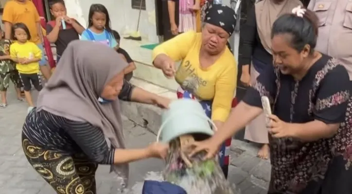 Siram anaknya pakai air kembang lantaran terlibat gangster (Foto: Capture)