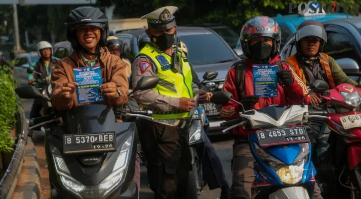 Sejumlah petugas kepolisian saat memberikan himbauan kepada kendaraan yang melintas di kawasan Tomang Raya, Grogol, Jakarta Barat, beberapa waktu lalu. (Poskota/Ahmad Tri Hawaari)