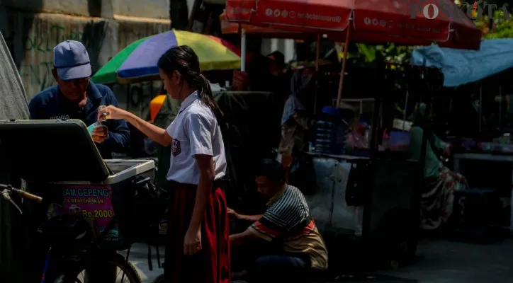 Aktivitas anak-anak saat membeli makanan maupun minuman di depan Sekolah Dasar Negeri 01 dan 03, Kramat, Jakarta Pusat, Selasa (6/8/2024). (Poskota/Ahmad Tri Hawaari)