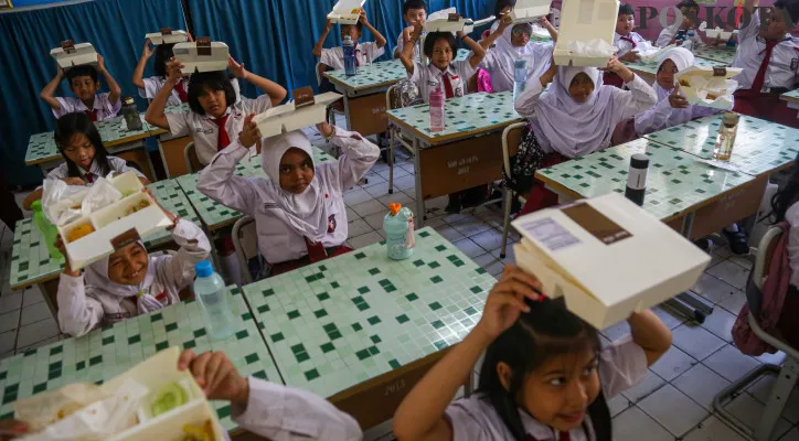 Sejumlah siswa menyantap Makan Bergizi Gratis di SDN 01 Gunung, Kebayoran Baru, Jakarta Selatan, Selasa (3/9/2024). Istana Kenegaraan mengklaim anggarannya dari APBN. (Poskota/Ahmad Tri Hawaari)