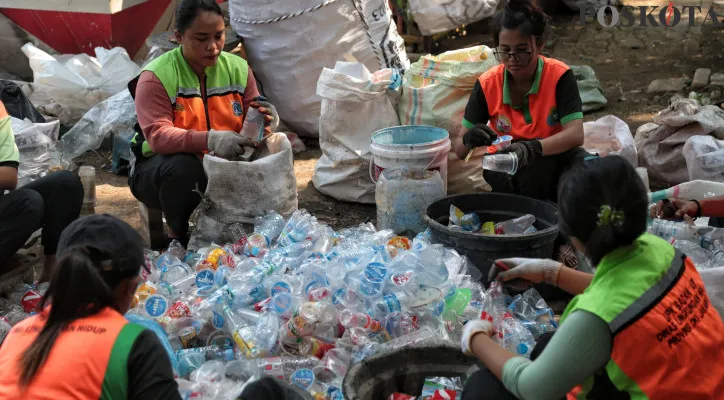 Aktivitas Petugas Dinas Lingkungan Hidup DKI Jakarta saat memilah sampah di Kawasan Cakung, Jakarta Timur, Jumat (11/10/2024). Pemerintah Provinsi (Pemprov) DKI Jakarta akan mulai menerapkan retribusi sampah rumah tangga per 1 Januari 2025, dengan dasar hukum Perda DKI Jakarta Nomor 1 Tahun 2024 tentang Pajak Daerah dan Retribusi Daerah, adapun besaran retribusi akan dihitung berdasarkan kapasitas KWH meter di setiap rumah tangga yang perhitungannya dari penyediaan TPS dan/atau TPS3R serta pengangkutan sampah sampai dengan pemrosesan akhir sampah. Poskota/Ahmad Tri Hawaari