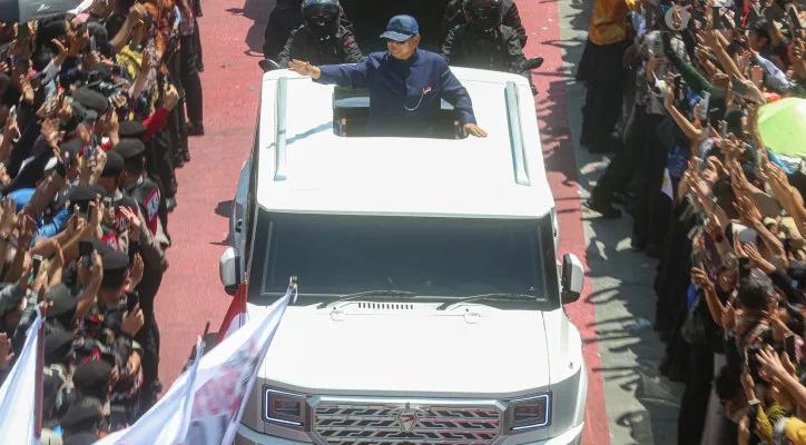 Presiden Prabowo Subianto dan Wakil Presiden Gibran Rakabuming Raka saat melambaikan tangan kepada ribuan masyarakat yang telah menanti di kawasan Jalan MH Thamrin hingga Sudirman, Jakarta Pusat, Minggu (20/10/2024) yang melintas menggunakan mobil Pindad Maung Garuda berwarna putih. (Poskota/Ahmad Tri Hawaari)