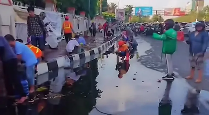 Rekaman video amatir warga berebutan mengambil minyak goreng yang tumpah ke jalan. (Tangkapan Layar/@fakta.indo)