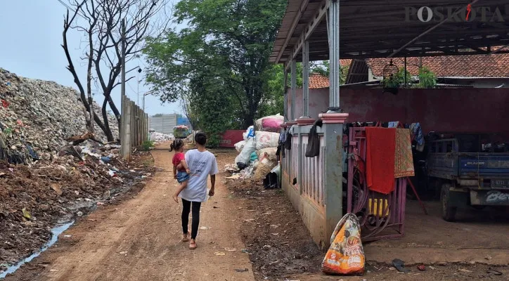 Warga melintas di dekat area robohnya dinding TPA Burangkeng, Setu, Kabupaten Bekasi pada Kamis, 14 November 2024. (Poskota/Ihsan Fahmi)