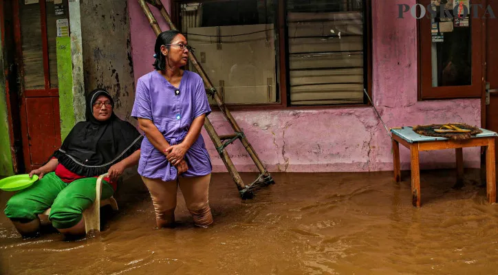 Aktivitas warga saat menerobos banjir di pemukiman padat penduduk kawasan Kebon Pala, Jakarta Timur. (Poskota/Ahmad Tri Hawaari)