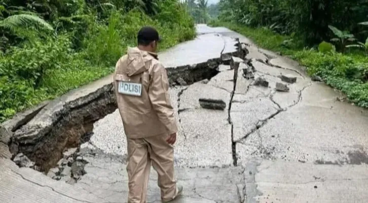 Salah seorang petugas BPBD Lebak saat memeriksa kondisi jalan amblas di Desa Prabugantungan, Kecamatan Cileles, Kabupaten Lebak. (Dok. BPBD Lebak)