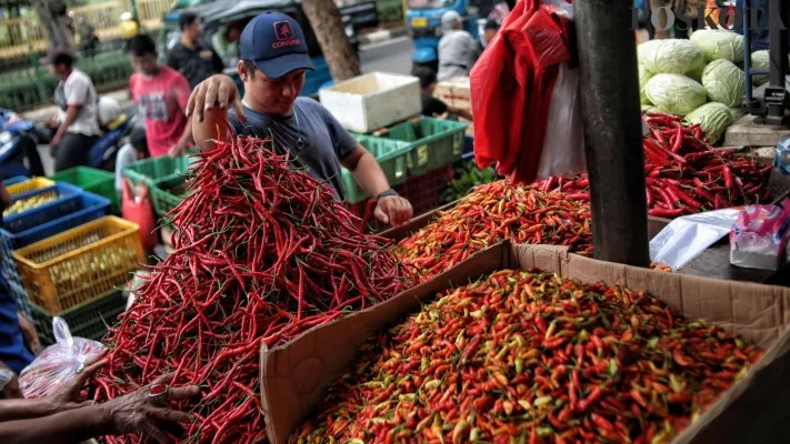 Foto: Pedagang Cabai memegang cabai dagangannya, Harga bahan pokok di Indonesia Stabil Usai Lebaran. (Dok. Poskota)