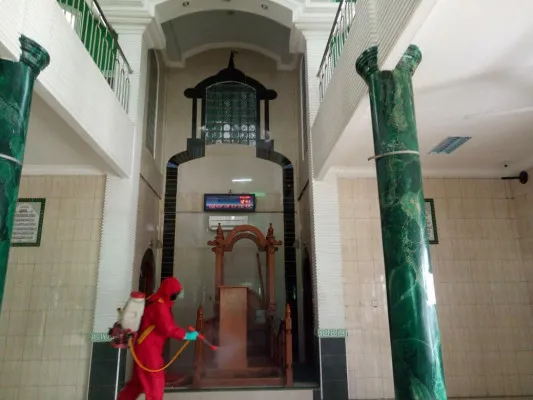 Petugas pemadam saat menyemprotkan disinfektan ke masjid yang akan gelar solat tarawih. (foto: istimewa)