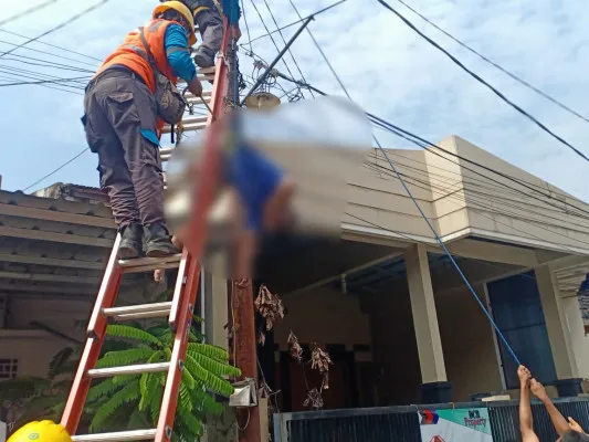 Petugas PLN berusaha mengevakuasi korban yang diduga tersengat listrik di Perum Purigading Villa Ciater, Blok C RT 03 RW 10, Kelurahan Jatimelati, Pondok Melati, Kota Bekasi pada Minggu (11/4/2021). (foto: istimewa)