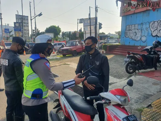 Iptu Fitri didampingi Dishub memberikan teguran kepada pengendara motor tidak menggunakan helm di Jalan Margonda. (foto: angga)