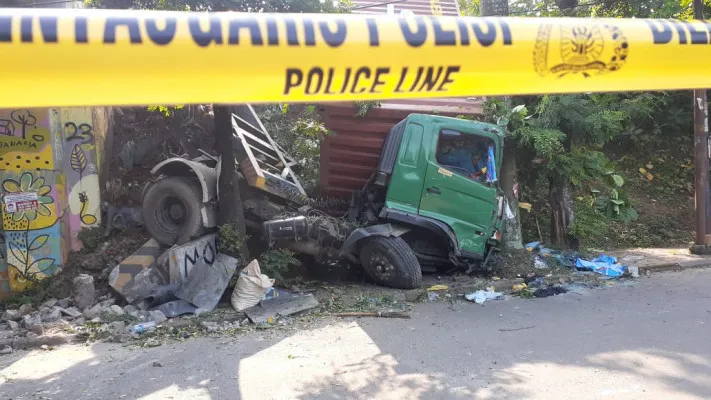 TANGSEL, POSKOTA.CO.ID-Sebuah mobil truk kontainer terjun bebas sekira lima meter dari jalan Tol Serpong ke Jalan Batam Rawa Mekar Jaya, Serpong, Selasa (27/4/2021).Truk tersebut terjun bebas usai menabrak pembatas jalan. Peristiwa kecelakaan tunggal itu terjadi pada pukul 2.30 WIB dini hari. Kanit Laka Lantas Polres Tangerang Selatan Iptu Agus Sutisna membenarkan adanya truk kontainer yang terjun bebas dari atas jalan Tol Serpong itu."Kejadiannya sekira pukul 02.30 WIB di jalan tol dari arah Pondok Ranji ke Pamulang. Truk itu menabrak pembatas jalan," katanya saat dikonfirmasi Poskota, Selasa (27/4).Agus menerangkan, kecelakaan tunggal tersebut terjadi akibat pengendara truk mengantuk. Akibat itu, truk kehilangan kendali hingga menabrak pembatas. "Supir mengantuk. Sehingga mobil yang dikendarainya menghantam jembatan ini, syukur alhamdulillah tidak ada korban jiwa. Supir selamat alami luka ringan," ungkapnya. Agus menuturkan, truk tersebut mengangkut besi 2,5 ton yang hendak menuju Taman Tekno, Serpong, Tangerang Selatan. "Isi truk sementara diketahui besi. Tapi kita masih mencari informasi ke perusahaan pemilik truk ini," tuturnya.Hingga saat ini, truk tersebut masih dibiarkan terbengkalai dan lokasi sekitar dipasangi garis polisi. Akibatnya, menutup salah satu jalan sehingga jalan akses jalan dialihkan satu jalur.Pantauan Poskota, truk bermuatan besi itu menghantam pohon di bawah jembatan Jalan Batam. Kondisi mobil dalam keadaan ringsek di bagian depan.Nantinya, bangkai truk tersebut bakal dievakuasi menggunakan crane."Truk dievakuasi sekira pukul 12.00-13.00 WIB, dengan crane dari Tanjung Priuk," pungkasnya.Bangkai truk dengan nomor polisi B 9040 CEH tersebut kini sudah diangkut oleh alat berat Satlantas Polres Tangsel. Ridsha Vimanda Nasution/KontributorFoto: Truk kontainer terjun bebas sekira lima meter dari jalan Tol Serpong ke Jalan Batam Rawa Mekar Jaya, Serpong, Selasa (27/4/2021). (Ridsha Vimansa)