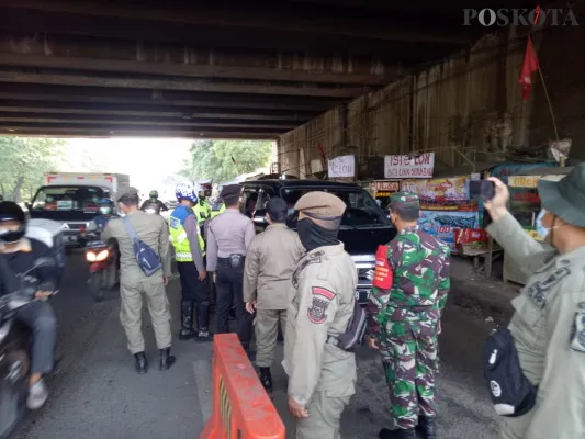 Petugas gabungan memutar balikkan sebuah mobil bus mudik tujuan Lampung di Posko Penyekatan Bitung, Kabupaten Tangerang, Senin (10/5/2021). (foto: ridsha vimanda nasution)